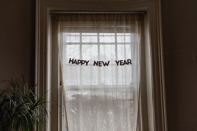 The words Happy New Year cut out in front of a window